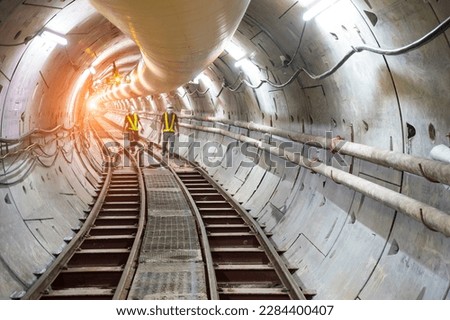 Soft focus and blurred lighting background of focus at railway.Engineer or technician control. Underground tunnel infrastructure. Transport pipeline by Tunnel Boring Machine for electric train subway. Royalty-Free Stock Photo #2284400407