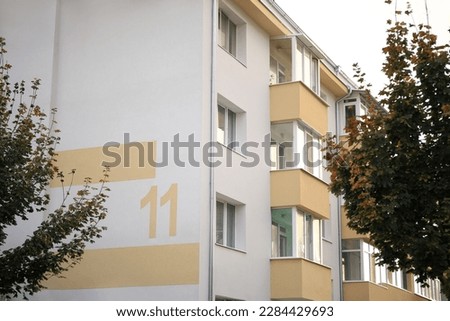 House number eleven on beige wall outdoors