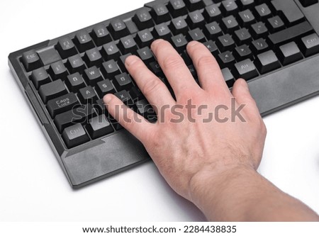 Male hand typing on a black computer keyboard