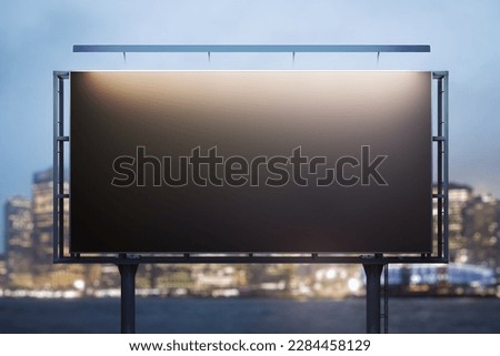 Blank black horizontal billboard on skyline background at evening, front view. Mock up, advertising concept