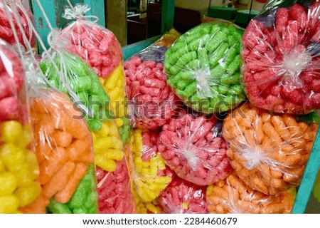 Closeup of Multi-colored crispy corn in a plastic bag for feeding fish at Thai Buddhist temple, Thailand.