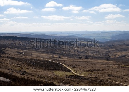 The path cutting along the bottom of Burbage valley with the hills and valleys on a mostly clear day with light clouds  Royalty-Free Stock Photo #2284467323