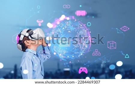 Portrait of little boy in VR goggles over blurry city background with double exposure of network interface. Concept of metaverse