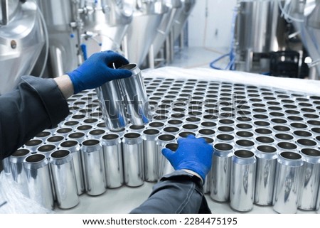 drink production manufactrure, worker's hand taking new aluminium cans Royalty-Free Stock Photo #2284475195