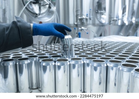 drink production manufactrure, worker's hand taking new aluminium cans Royalty-Free Stock Photo #2284475197