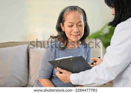 Beautiful and happy senior Asian woman is discussing her medical treatment plan with a doctor in the examination room at a hospital. Health care concept