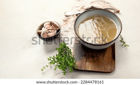 Broth in Bowl on gray background, healthy food, top view, copy space