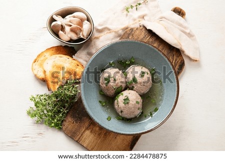 Canederli or Knodel in broth with  typical pasta or dumplings for Alps, Alto Adige, German, Italian, Austrian cuisine. Made from stale bread, milk, eggs, speck on a white background. Top view. Royalty-Free Stock Photo #2284478875