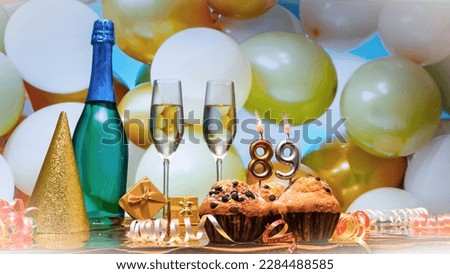 Happy birthday champagne background with number of candles  89. Beautiful congratulations copy space for anniversary.
Holiday decorations with balloons with a bottle of champagne in pastel colors.