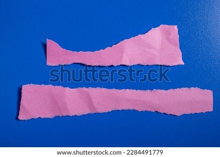 Ripped pink paper piece on a isolated blue background