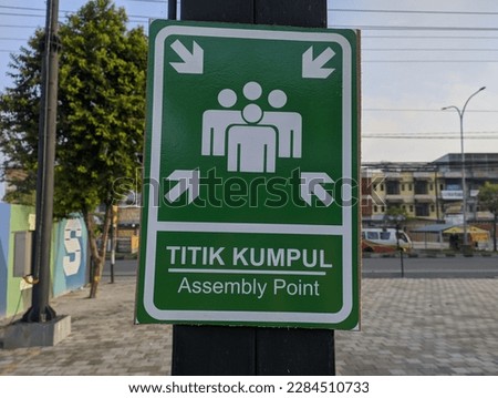 A sign board that says assembly point or 'Titik Kumpul'