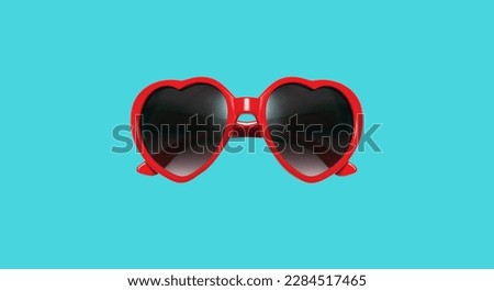 Red heart shaped sunglasses isolated on blue background