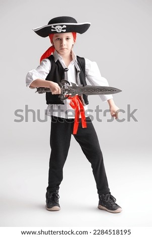 A full-length shot of a cute little boy wearing a costume of a pirate. Party with costumes for kids. White studio background.