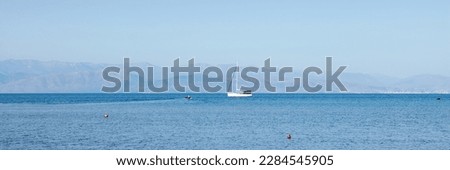 Fantastic seaside view at the sea with the alone yacht on the horizon, Corfu island, Greece. Sunny day, minimalism, calm and silence.