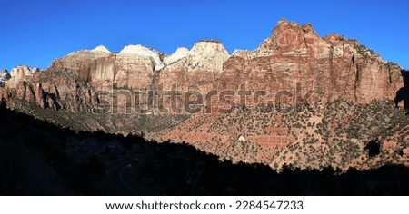 Nestled within the stunning red rock formations of Utah's Parks, this breathtaking image captures the essence of the American West. Towering sandstone cliffs soar into a bright blue sky.