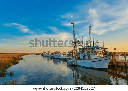 Sunset with shrimp boats along a dock at Tybee Island, Ga. Royalty-Free Stock Photo #2284552327