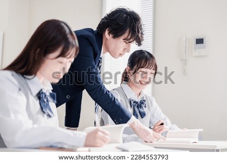High school student asking a question to her teacher in the classroom Royalty-Free Stock Photo #2284553793