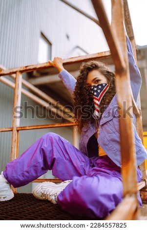 Cool dancer on the street in stylish clothes with american bandana dancing. young dancing woman showing some moves. Sport, dancing and urban culture concept.