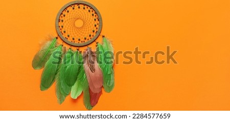 Dream catcher on orange background with space for text
