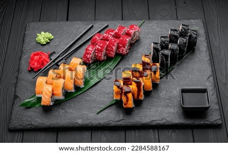 Assorted sushi nigiri and maki big set on slate. A variety of Japanese sushi with tuna, crab, salmon, eel and rolls. Top view. Asian cuisine. Photo for the menu.