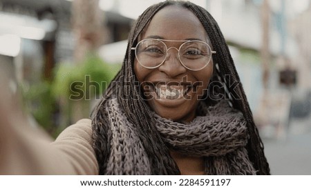 African woman taking selfie smiling at street