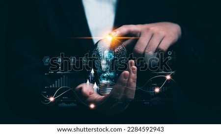 Businessman holding light bulb with digital marketing strategy idea ,target of investment growth on currency and dollar cost averaging. financial and banking and virtual hologram of statistics.