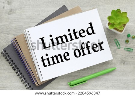 business concept. There are three notebooks on the work table near a plant in a pot with text-limited time offer