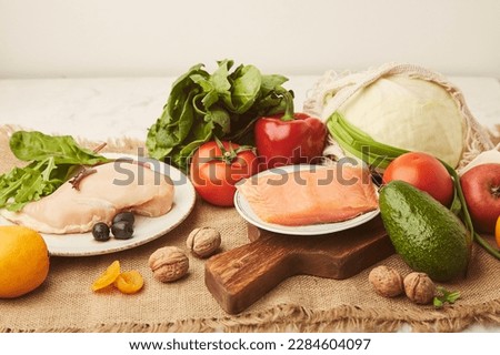 Menu for low carb, FODMAP diet food. Vegetables, fruits, chicken fillet, smoked salmon, greens, nuts, olives. Healthy lifestyle. Royalty-Free Stock Photo #2284604097