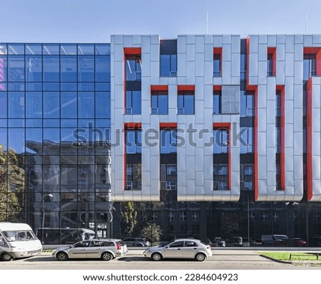 Modern building with an interesting finish. Material of vertical aluminum and orange panels. Sunny day.