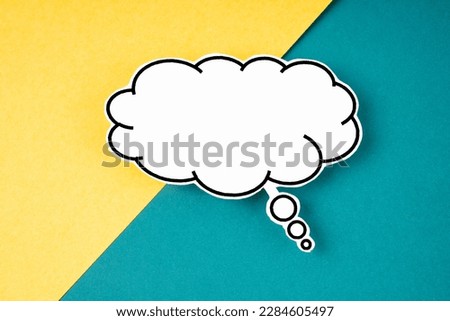 White speech bubble shaped post it note on yellow and green background with copy space.