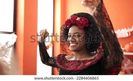 African american woman wearing katrina costume having halloween party at home