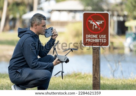 Man is sad that he is not allowed to fly his quadcopter state park no drone area. Operator is unauthorised to use UAS near restriction sign