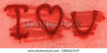 Red painted out over "I love you" and heart symbol message with red ink on white line notebook lie on white wall. Sad and disappointed in love delete “I love you” on Valentine’s day on fence.