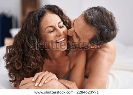 Man and woman smiling confident lying on bed kissing at bedroom Royalty-Free Stock Photo #2284623991