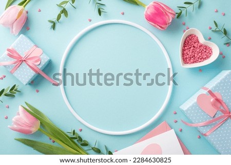 Mother's Day concept. Top view photo of empty round frame tulips gift boxes envelope with letter and heart shaped saucer with sprinkles on isolated pastel blue background with copyspace in the middle