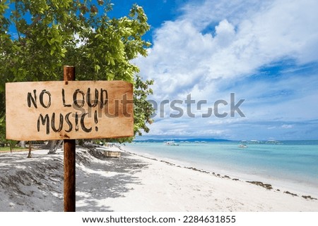 A no loud music sign at the beach. A ban on loudspeakers at a beachfront property.