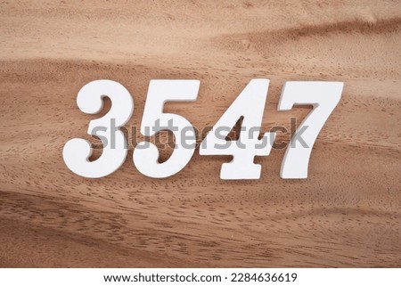 White number 3547 on a brown and light brown wooden background.