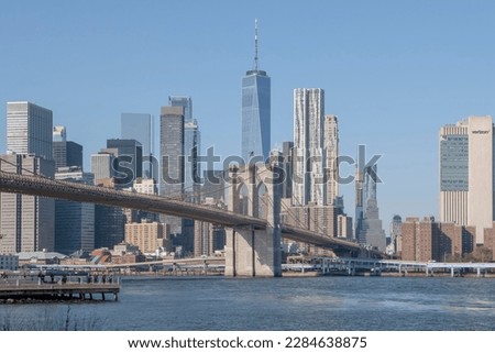 New York, Brooklyn Bridge and downtown skyline on sunny day. The famous bridge with modern skyscrapers on background in the city of New York.Daylight Timelapse Manhattan Bridge Over Lower Manhattan 