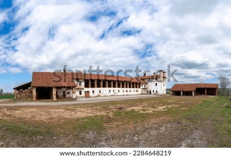 An old abandoned farmstead with barns above the stables and the fortified manor house, typical rural architecture of the Po Valley plain in the province of Cuneo, Italy Royalty-Free Stock Photo #2284648219