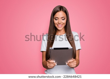 Portrait of pretty charming confident woman having tablet in hands isolated on grey background