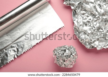 Foil ball with aluminium rolls on pink background. Top view Royalty-Free Stock Photo #2284650479