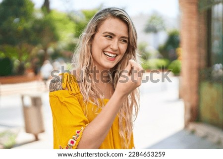Young woman smiling confident doing italian gesture at street Royalty-Free Stock Photo #2284653259