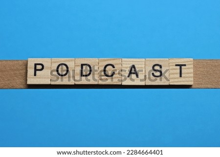 word podcast made from wooden gray letters lies on a blue background