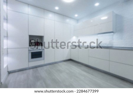 Blurred view of modern kitchen interior with white furniture