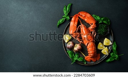 Luxurious boiled spiny lobster with spices, basil and lemon on a black stone plate. Free space for text. Royalty-Free Stock Photo #2284703609