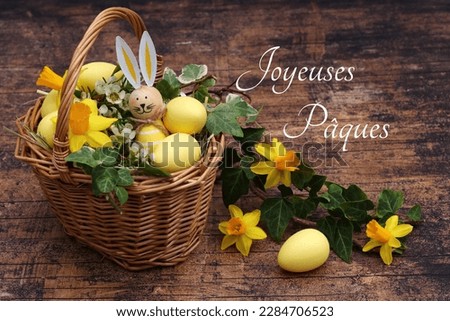 Decorative planted Easter basket with Easter eggs and flowers, French inscription means Happy Easter.