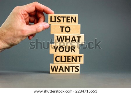 Support your client symbol. Concept words Listen to what your client wants on wooden blocks on a beautiful grey background, copy space. Businessman hand. Business, support your client concept.