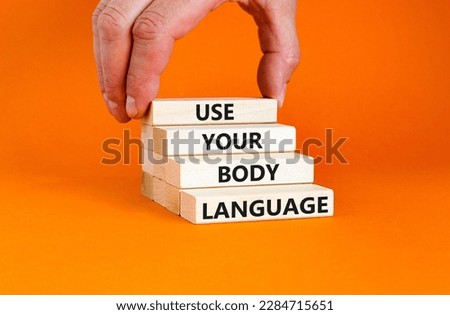 Use your body language symbol. Concept words Use your body language on wooden block. Beautiful orange table orange background. Motivational business Use your body language concept. Copy space.