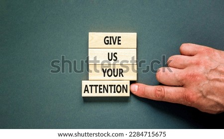 Give us your attention symbol. Concept words Give us your attention on wooden block. Beautiful grey table grey background. Motivational business give us your attention concept. Copy space.
