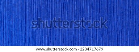 Top view of dark blue crinkled and crumpled fabric texture. Seamless pattern cloth abstract background